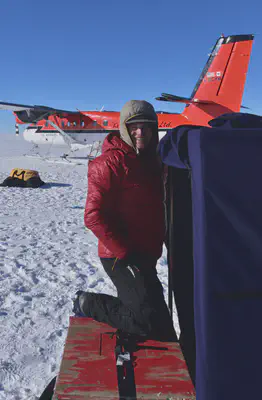 Me climbing into the radar shelter. The Twin Otter that we use for our 1.5 hour commute from the South Pole is in the background.